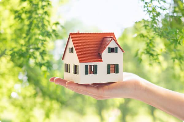 住宅模型を手のひらに乗せているイメージ、住まいの価値を見つめる様子