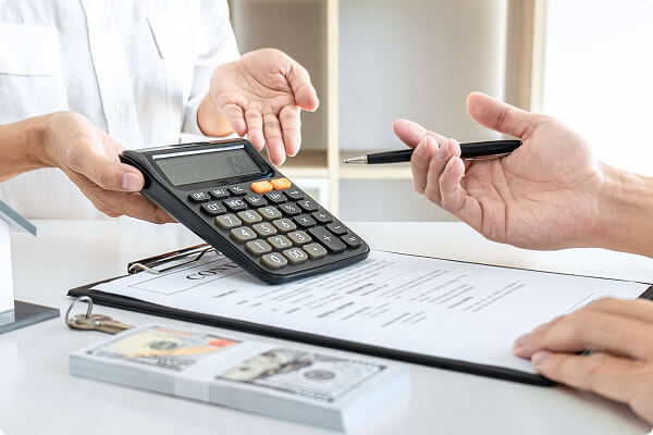 売却価格についての説明を受けている様子、大きな電卓と契約書類