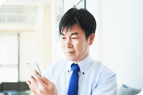 スマートフォンで情報を見る男性のお客様